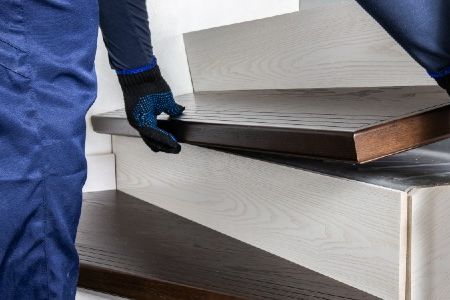 Mann verkleidet Treppe mit neuem Holz